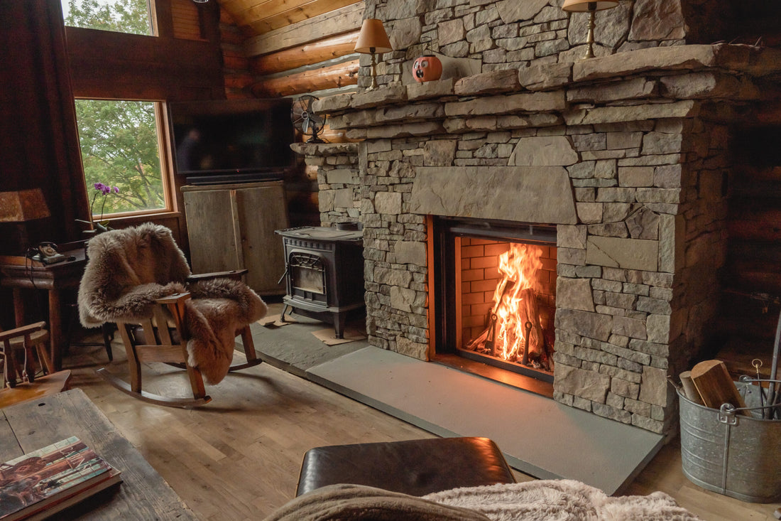 Cozy living room with stone fireplace, wooden chair, and television.