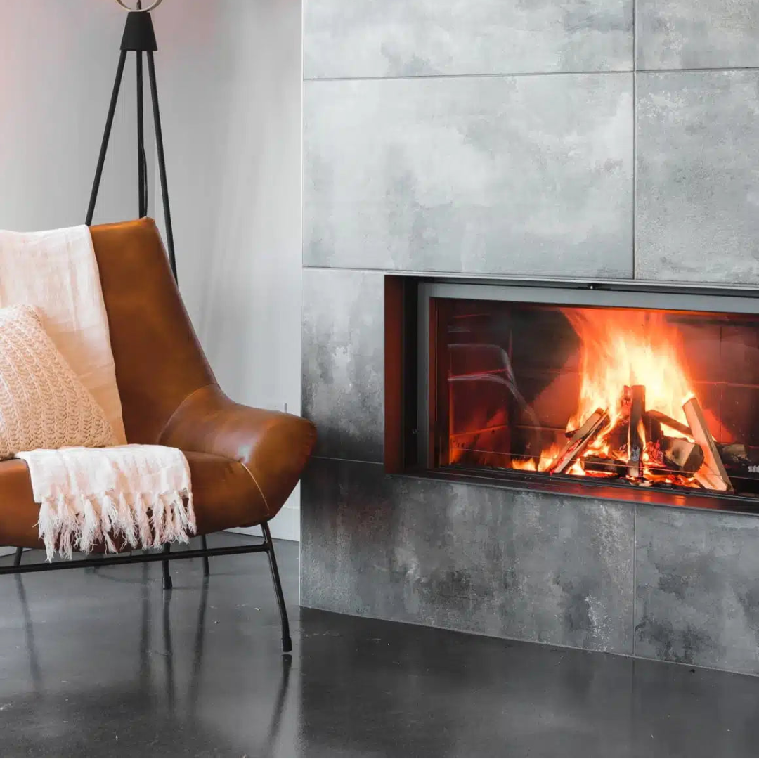 Modern living room with a leather chair, floor lamp, and a fireplace.